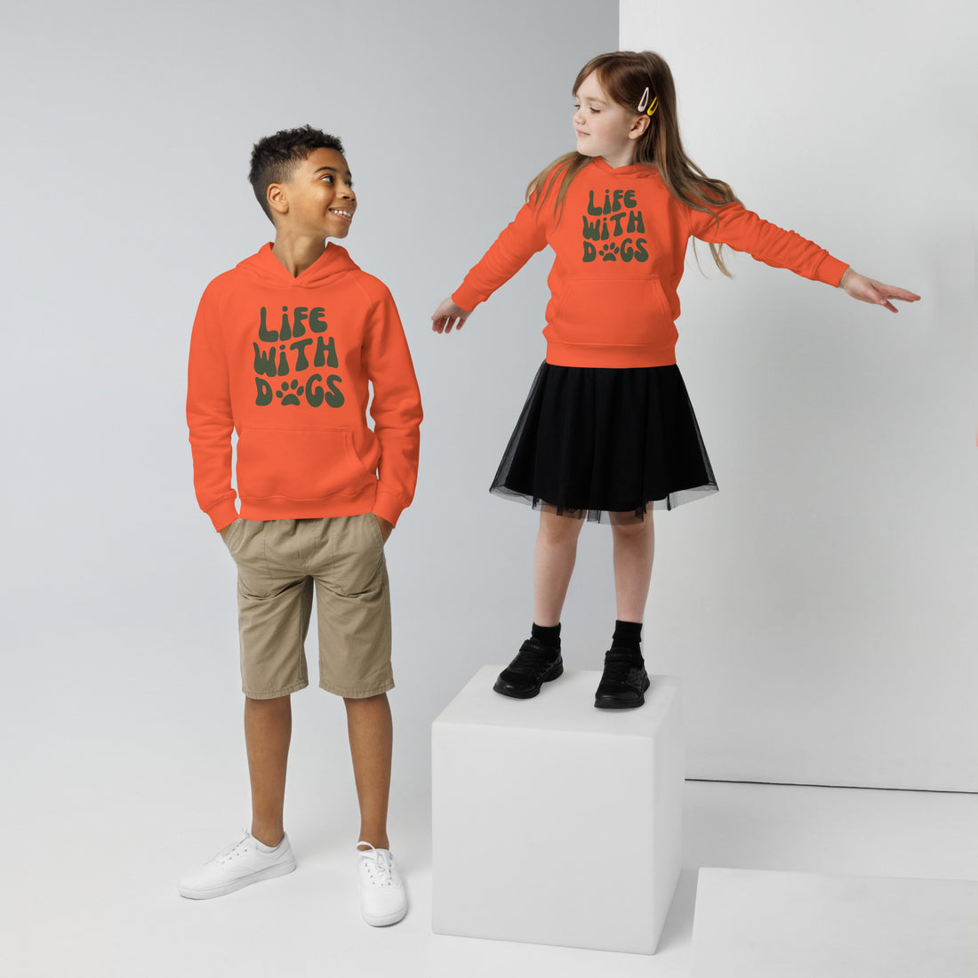 Children wearing burnt orange dog lover hoodies featuring LIFE WITH DOGS slogan and paw print design